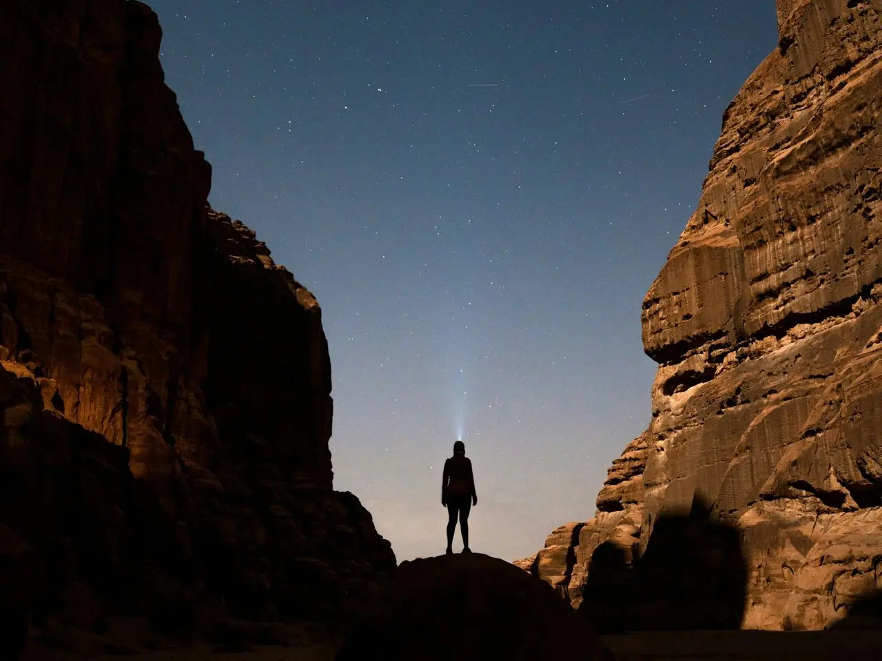 a person standing in the middle of a desert at night